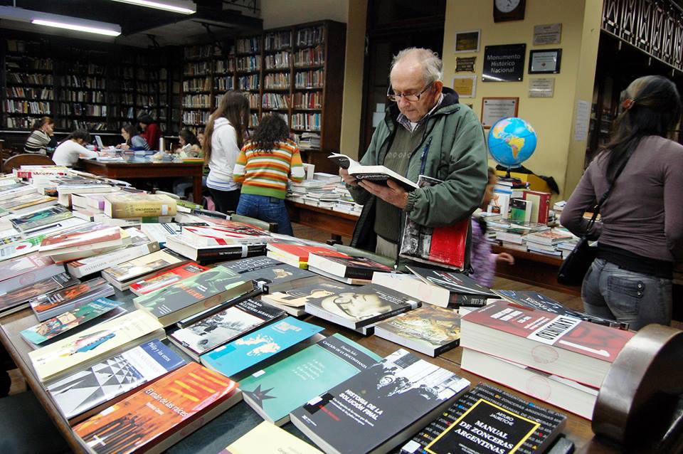 Imagen ilustrativa de gente revisando novedades en sala de lectura